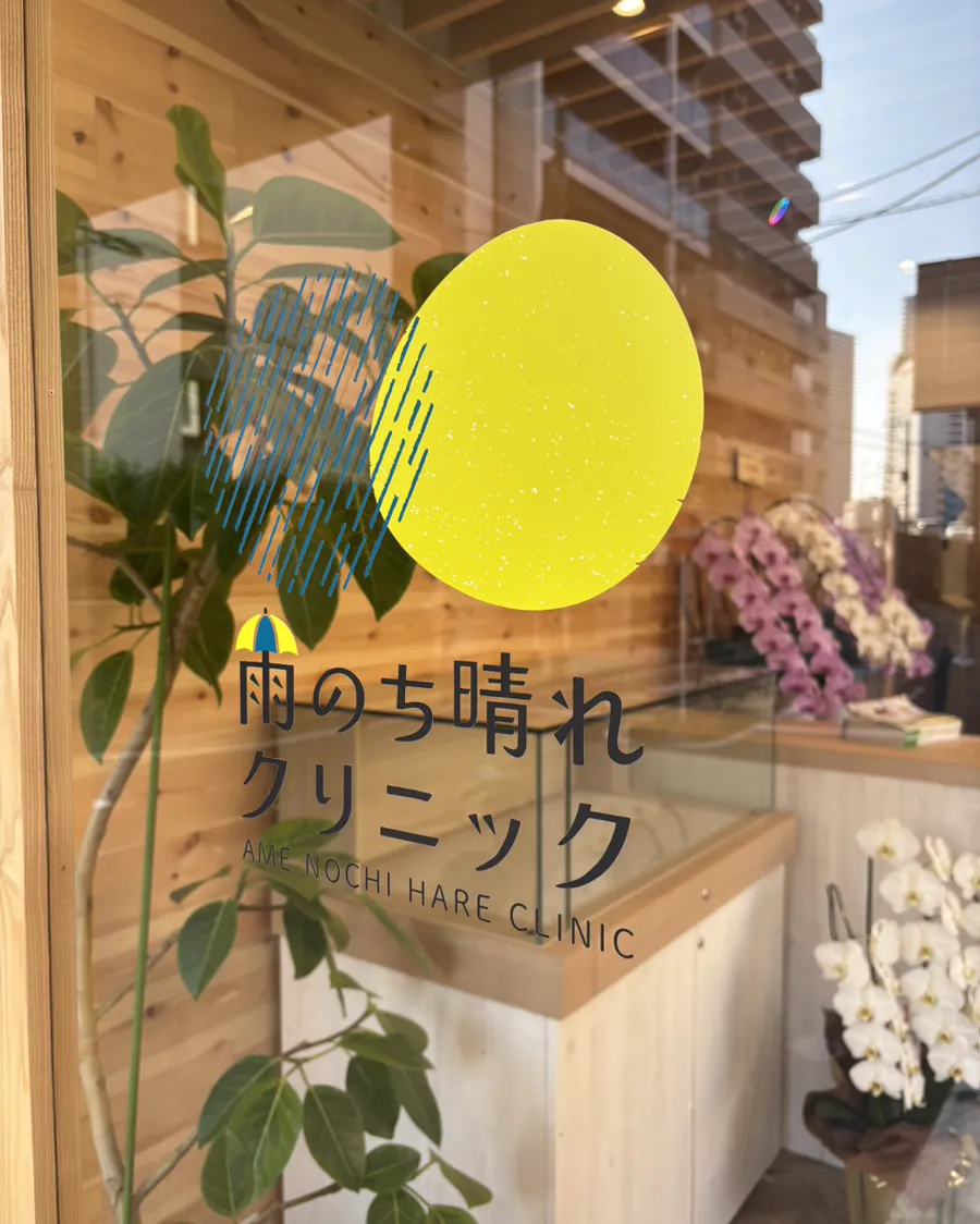 入口のガラスに描かれた雨のち晴れクリニックのロゴ